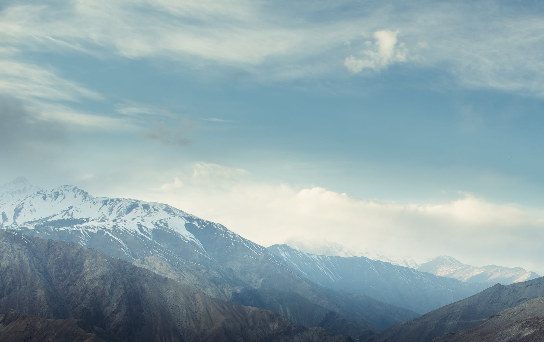 snow covered mountains under cloudy sky